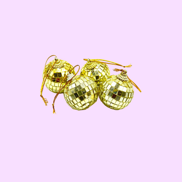 Four gold disco ball ornaments on a white background