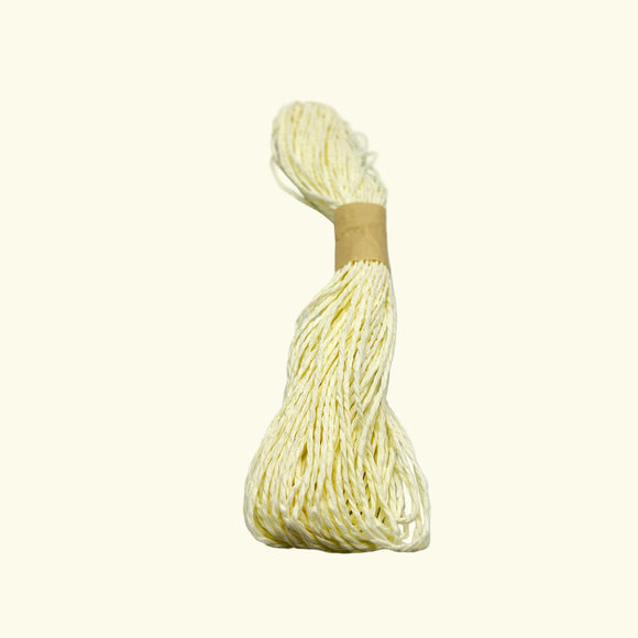 Ball of white yarn with a wooden spool on a light beige background