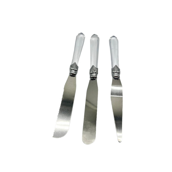 Three silver butter knives with decorative handles on a light gray background